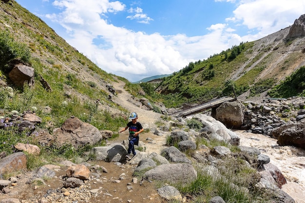 Boy at the KyzylKol River surrounded by the Caucasus Mountains near Elbrus Jilysu Russia