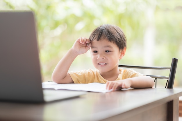 The boy learning on line and using laptop