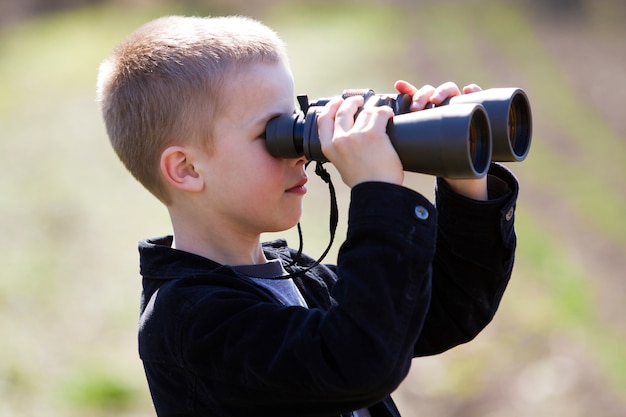 Boy looking through binoculars in distance