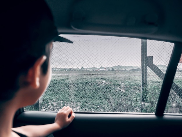 Photo boy looking through car window