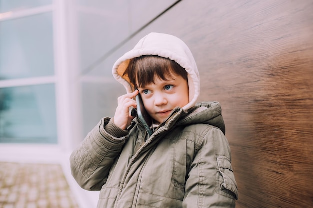 A boy looks at his phone in the city of lifestyle Modern technologies Modern children A child and a phone