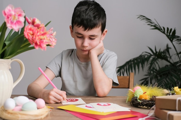 Boy making Easter greeting card Paper crafts activity in kindergarten or learning at home