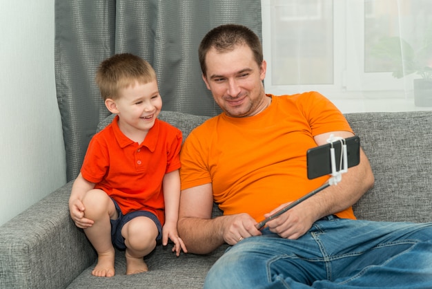 Boy and man looking in the smartphone during online call and smiling