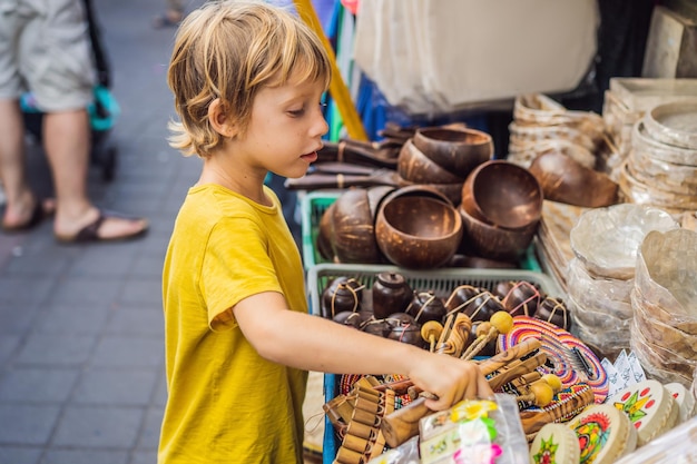 Boy at a market in ubud bali typical souvenir shop selling souvenirs and handicrafts of bali at the