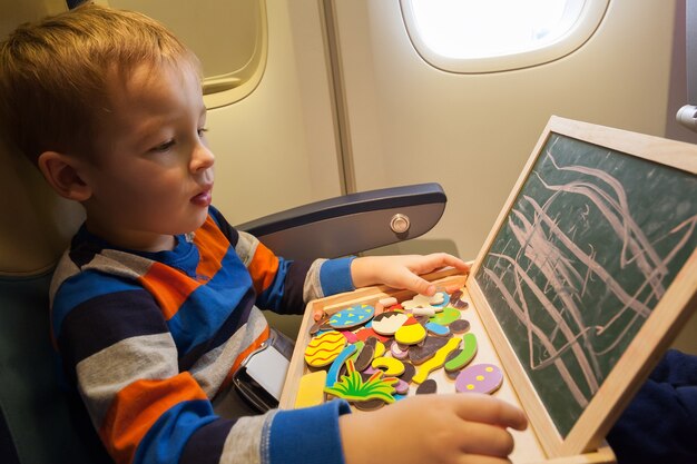 Boy in the plane drawing on board with chalk