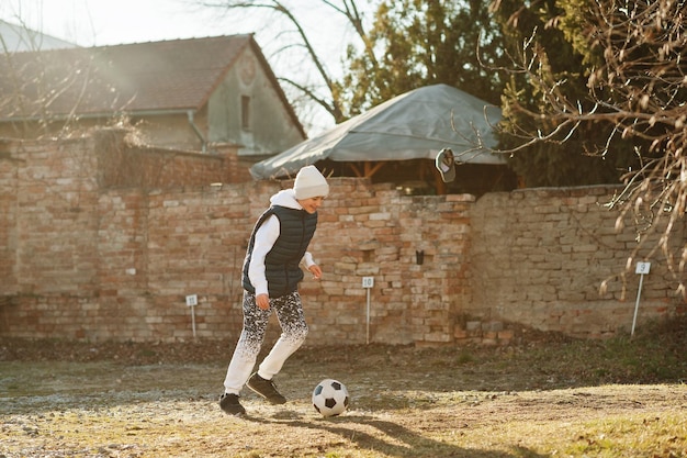 Boy play with the soccer ball in spring sunny day