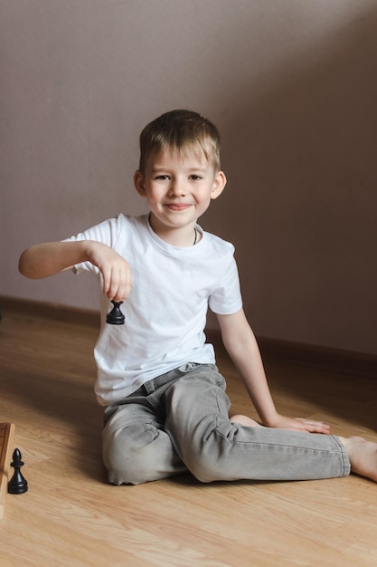 Boy playing chess on the floor