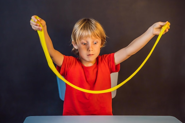 Boy playing hand made toy called slime Child play with slime Kid squeeze and stretching slime