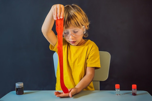 Boy playing hand made toy called slime Child play with slime Kid squeeze and stretching slime