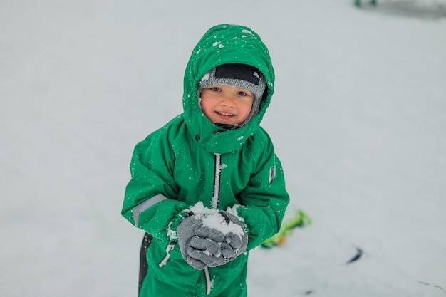 Boy playing outdoors in winter outdoor gamesA little boy is playing in the snow behind the boy sled