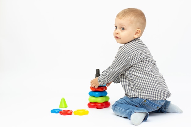 Boy playing with plastic toys white background isolated.