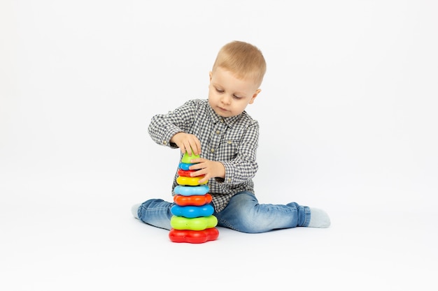 Boy playing with plastic toys white background isolated.