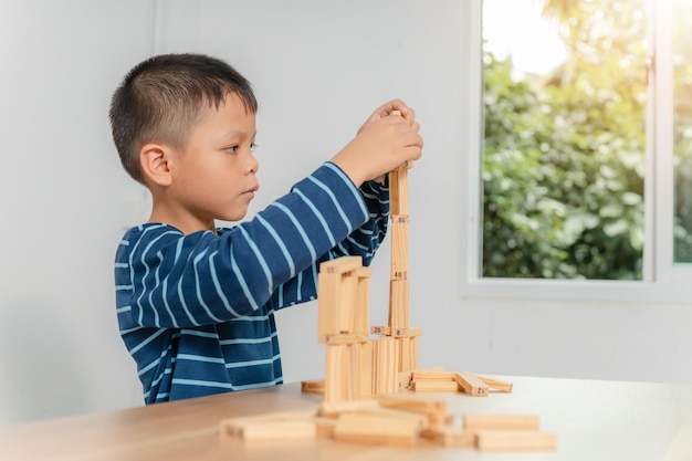 Boy playing with wooden blocks at home