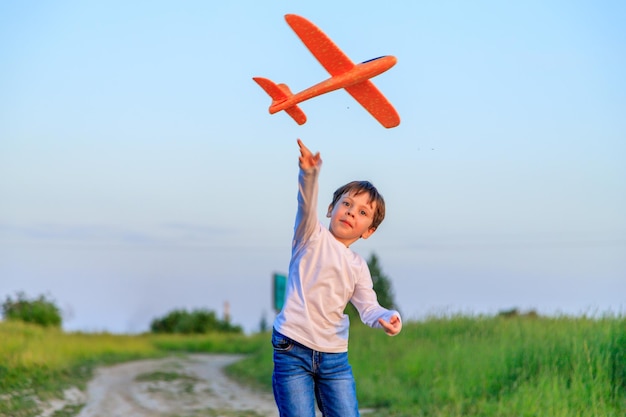 A boy plays in an airplane in nature in the summer The boy dreams of the future Buying real estate advertising An article about choosing a profession A happy child