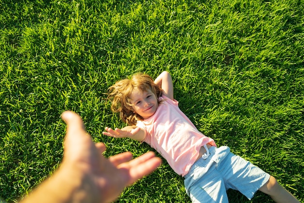 Boy pull father hand. Follow me, hand-in-hand walking on sunny day. Kid holding man's hand and leading him on nature outdoor.