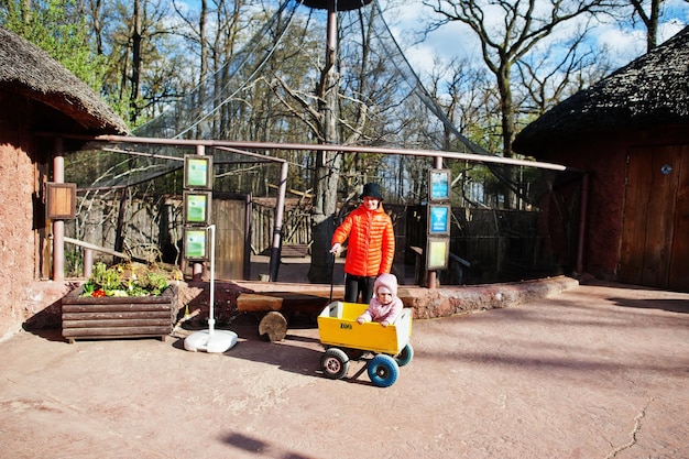 Boy pulls wooden trolley with sister at zoo