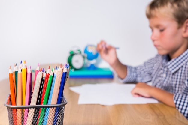 Boy, pupil working, learning, studying from home, making notes in notepad. Student, education, stay at home, homeschooling concept