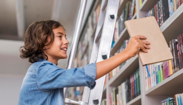 Boy putting back a book on the shelf