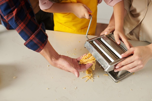 Boy Putting Pasta Dough into Machine