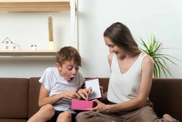 Boy rejoices at his mothers gift. Present for son. Child got gift.