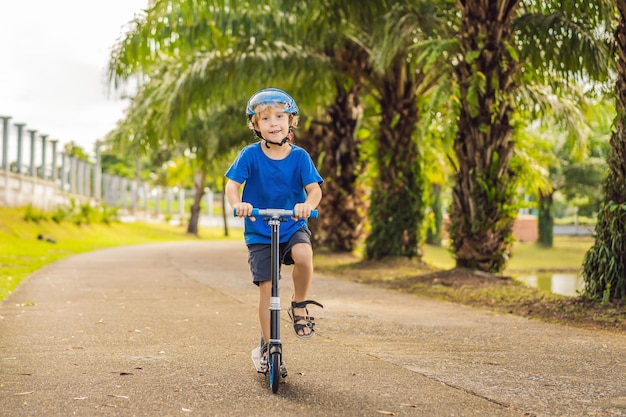 Boy riding scooters outdoor in the park summertime Kids are happy playing outdoors