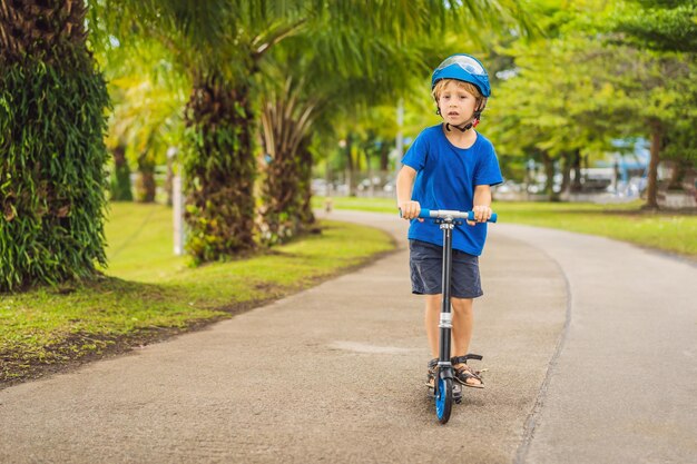 Boy riding scooters outdoor in the park summertime Kids are happy playing outdoors