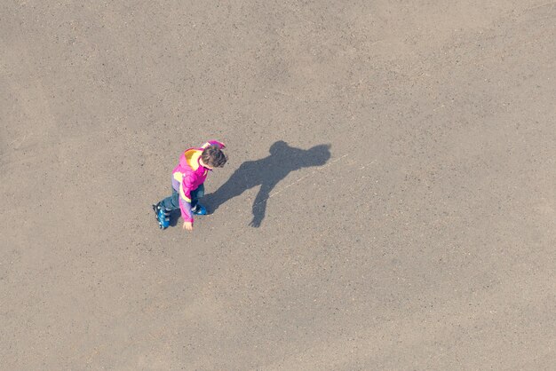 Boy rollerblading on the asphalt a top view