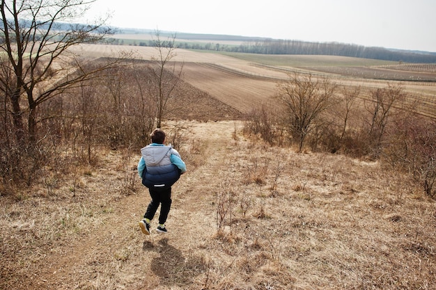 Boy running on field in early spring