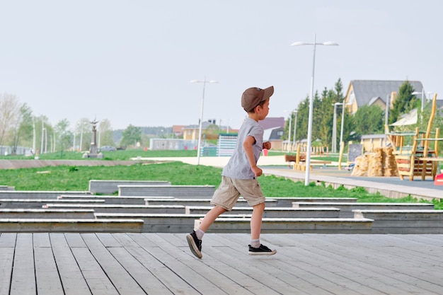 Boy runs on the veranda in the street Happy and active childhood of the child