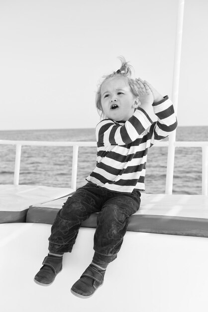 Boy in sailor shirt sail in blue sea