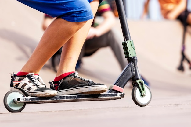 A boy on a scooter and in a skate park makes incredible jumps and tricks Extreme jumping on a scooter The concept of a healthy lifestyle and sports leisure