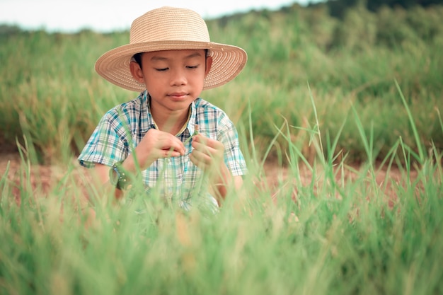 Boy sitting in grassland on daytime