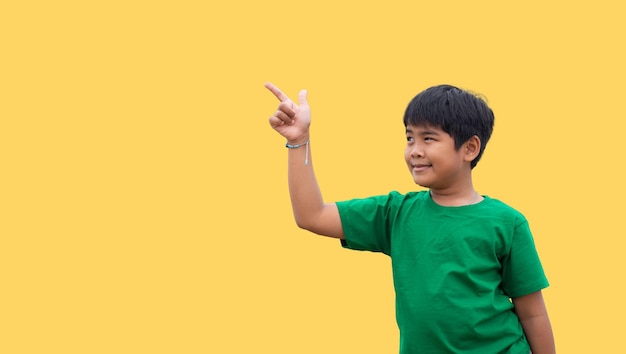 The boy smiled and pointed his hand to his side on a yellow background