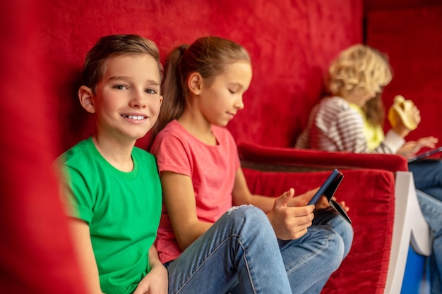 Boy smiling at camera sitting resting with classmates