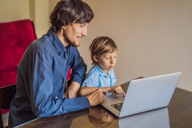 Boy studying online at home using laptop Father helps him learn Studying during quarantine Global pandemic covid19 virus