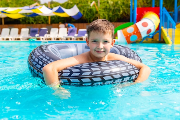 Boy swim on inflatable ring in swimming pool outdoors