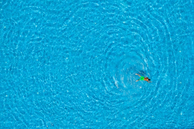 Boy swimming in a pool top view