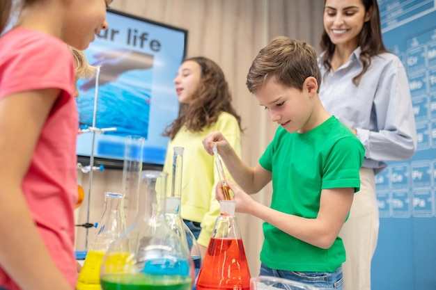 Boy taking liquid from test tube with pipette