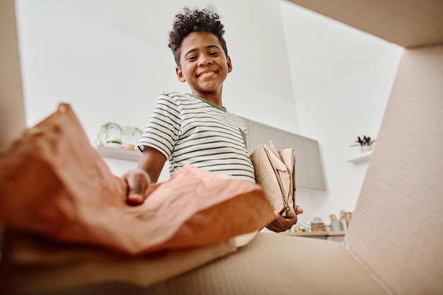 Boy throwing paper in box for recycling