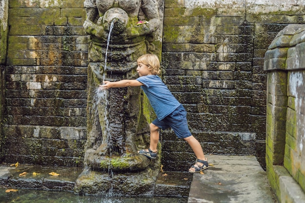 Boy tourist in Old Hindu temple of Goa Gajah near Ubud on the island of Bali, Indonesia. Travel in Bali with children concept