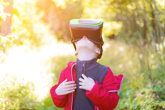 A boy in virtual reality glasses on the street Modern children Modern technologies