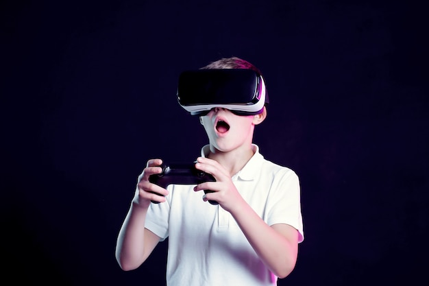 Boy in VR goggles playing with gamepad