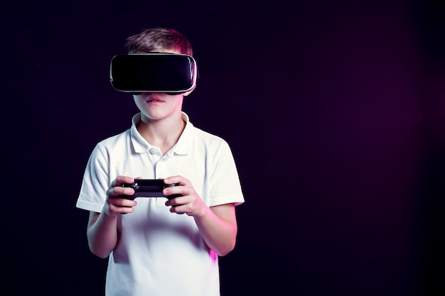 Boy in VR goggles playing with gamepad