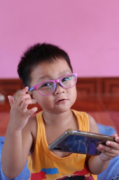 Boy wearing glasses and playing smartphone