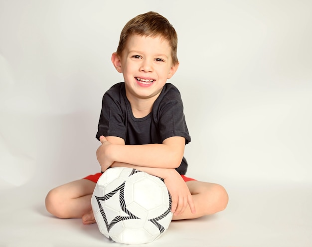 A boy on a white background. Smiling handsome boy sitting on a white background