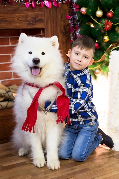 A boy with a big dog at Christmas.