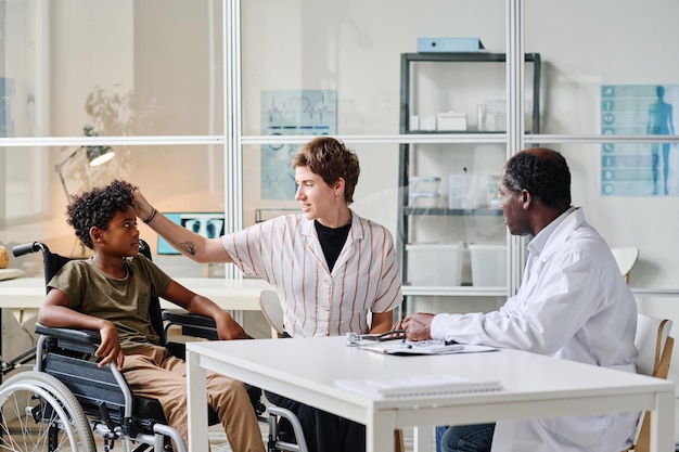 Boy with disability visiting doctor with his mom