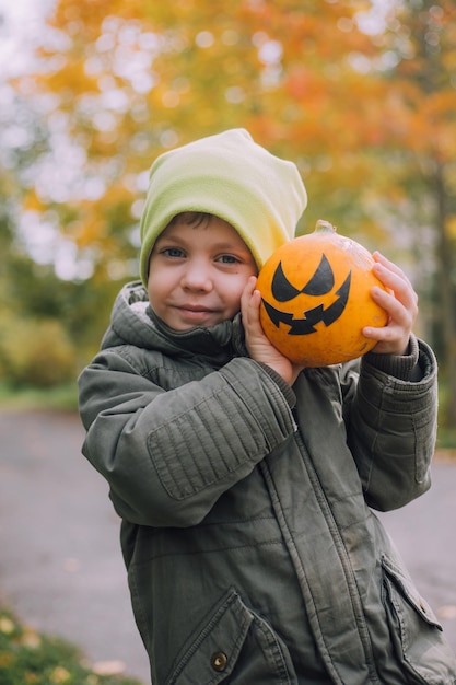 A boy with a Halloween pumpkin with eyes The feast of fear Halloween An orange pumpkin with eyes