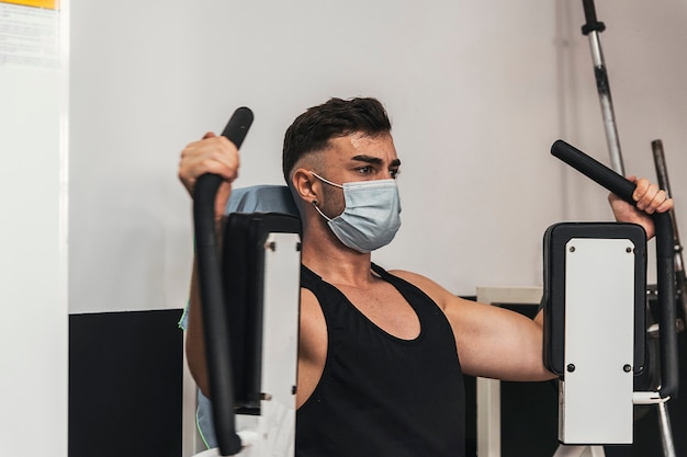 Boy with mask doing chest exercise in gym