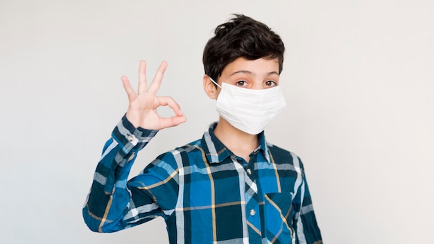 Boy with mask showing ok sign